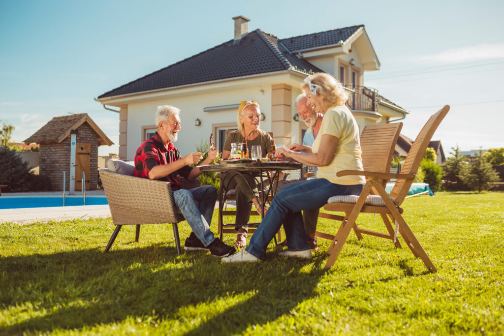 Ältere Freunde beim Mittagessen im Garten